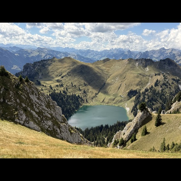 Ein türkisfarbener See in einer alpinen Mulde